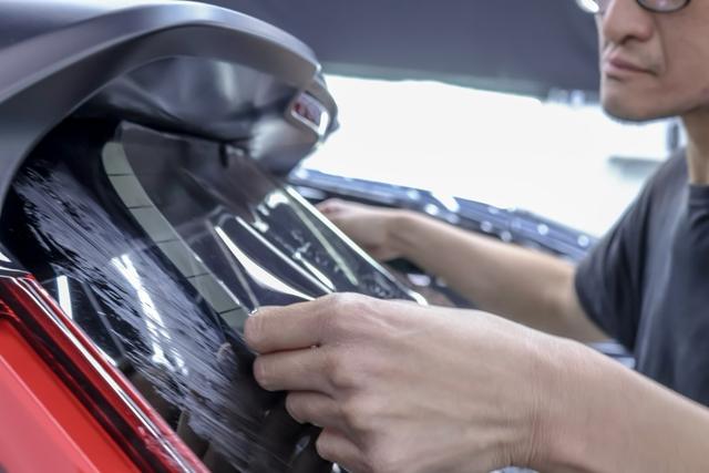Installer smoothing film onto a rear window at 68 Auto Film