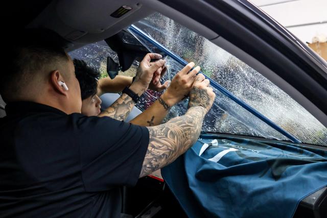 Installer applying clear film to a windshield at 68 Auto Film