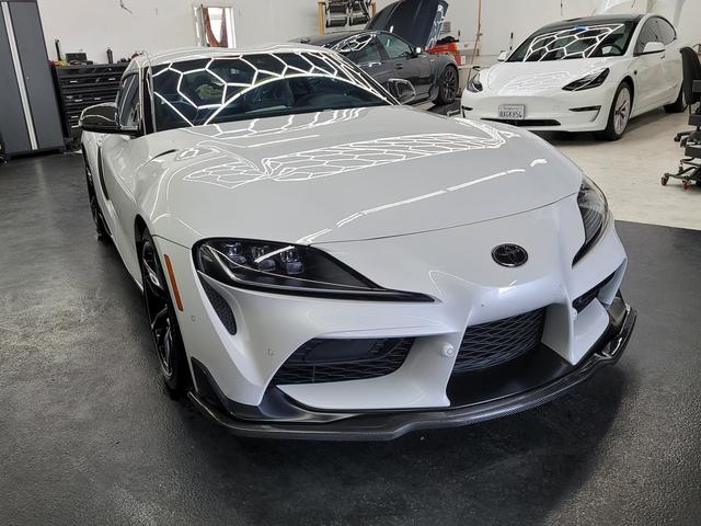 White Toyota GR Supra with doors open in the 68 Auto Film bay